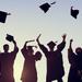 Silhouettes of a group of students throwing their mortarboards in the air to signify graduating Thumbnail