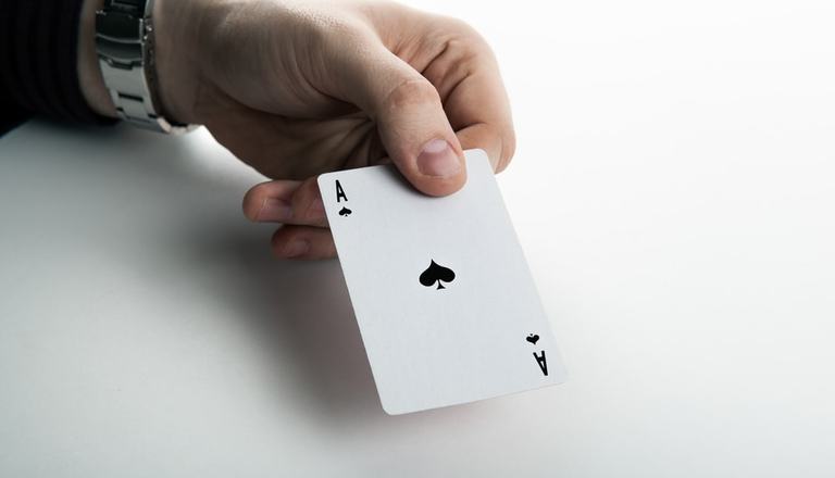 Hand holding and showing the ace of spades card