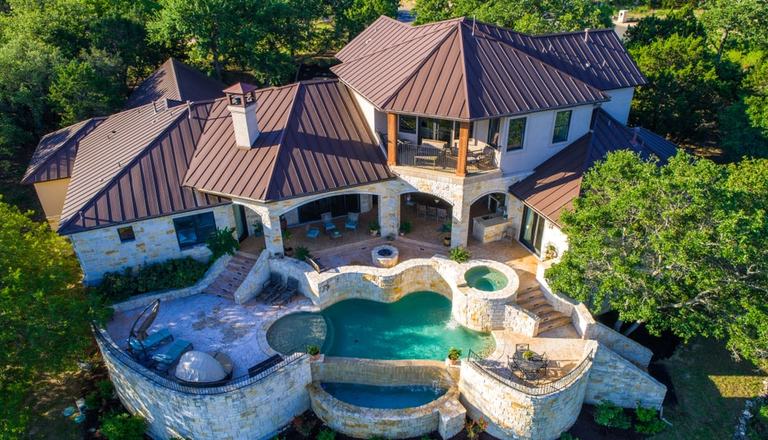 Aerial photograph of a luxurious mansion with a swimming pool in the back garden