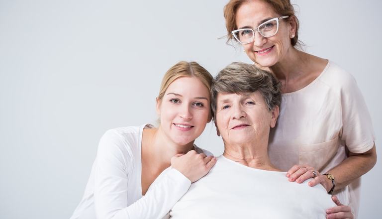 Three women - presumably related - of different age groups smiling at the camera