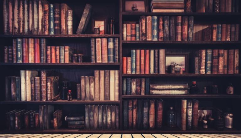 Landscape shot of old, thick books in a wooden bookshelf