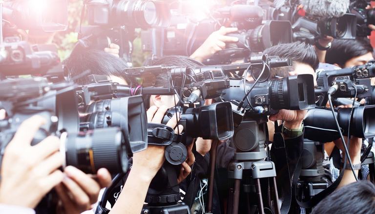 Multiple cameras and photographers aiming at the right from the left