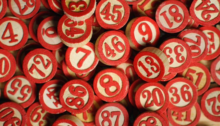 Numbers printed in red on circular wooden pieces