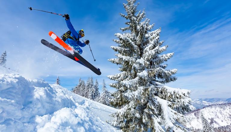 Skiing male jumping over snow down a mountain