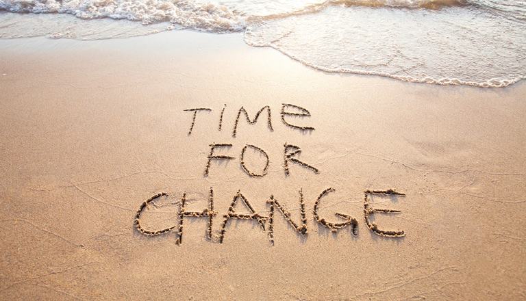 The message  "Time to Change" drawn out in the sand