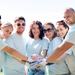 Group of adults smiling at the camera with hands together to suggest community and volunteering Thumbnail