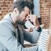 Young man sitting down and pinching the top of his nose and grimacing to highlight his frustration Thumbnail