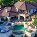 Aerial photograph of a luxurious mansion with a swimming pool in the back garden Thumbnail