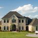 Large stone-and-brick mansion facing the camera, with a new silver car parked to the right Thumbnail