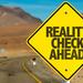 Road sign next to road with the text Reality Check Ahead on it Thumbnail