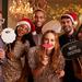 Group of adults celebrating Christmas with festive hats and signs Thumbnail
