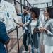 Group of colleagues in smart casual discussing documents and graphs attached to a whiteboard Thumbnail