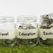 Three glass jars in a row with various amounts of coins in. One jar is labelled "Travel", another is labelled "Education", the third is labelled "Savings" Thumbnail