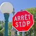 Close-up of a red stop sign with French equivalent, Arrete, above the word Stop Thumbnail